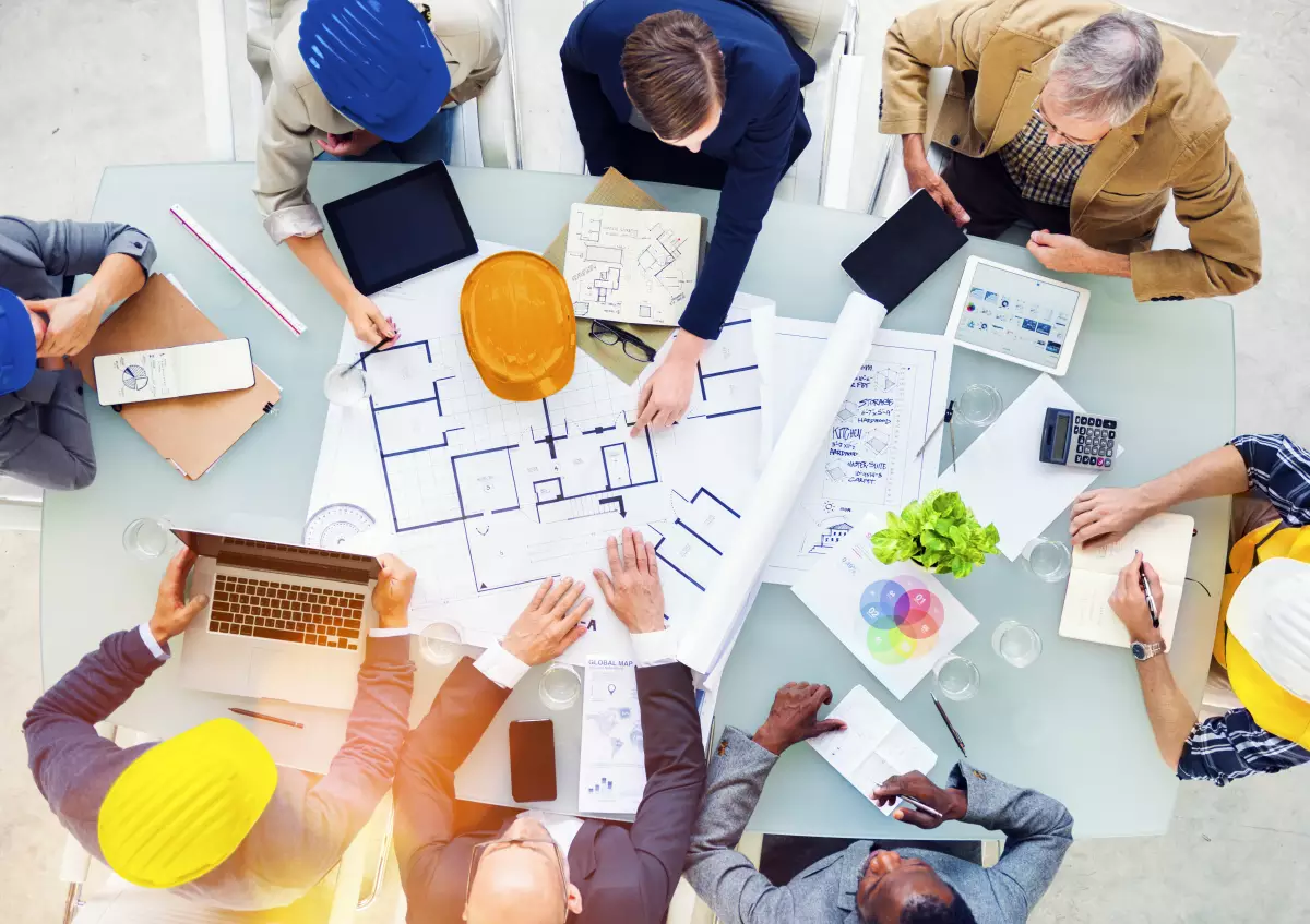 construction hors site – une table d’ingénieurs et d’architectes qui débattent sur des plans