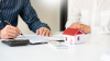 Avantages de l’immobilier neuf - Les agents immobiliers expliquent le document aux clients qui viennent s'adresser pour acheter une maison