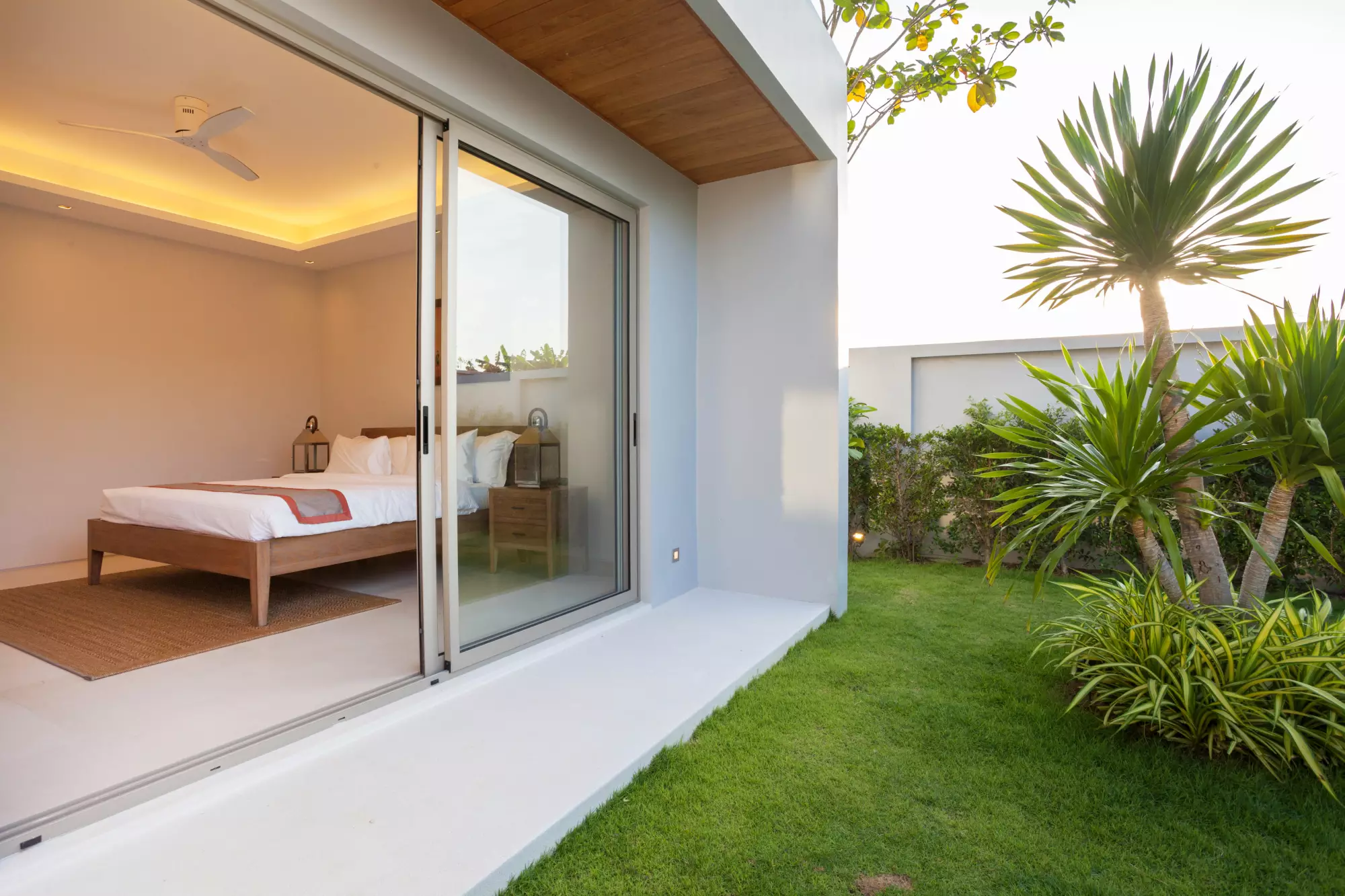 Vue d'une chambre et donnant sur un jardin privatif par une baie vitrée