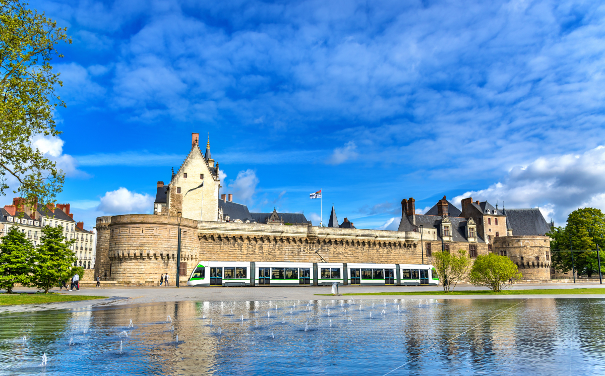 Quartier Bouffay Nantes – Le tramway qui passe entre le château des Ducs de Bretagne et le Miroir d’Eau