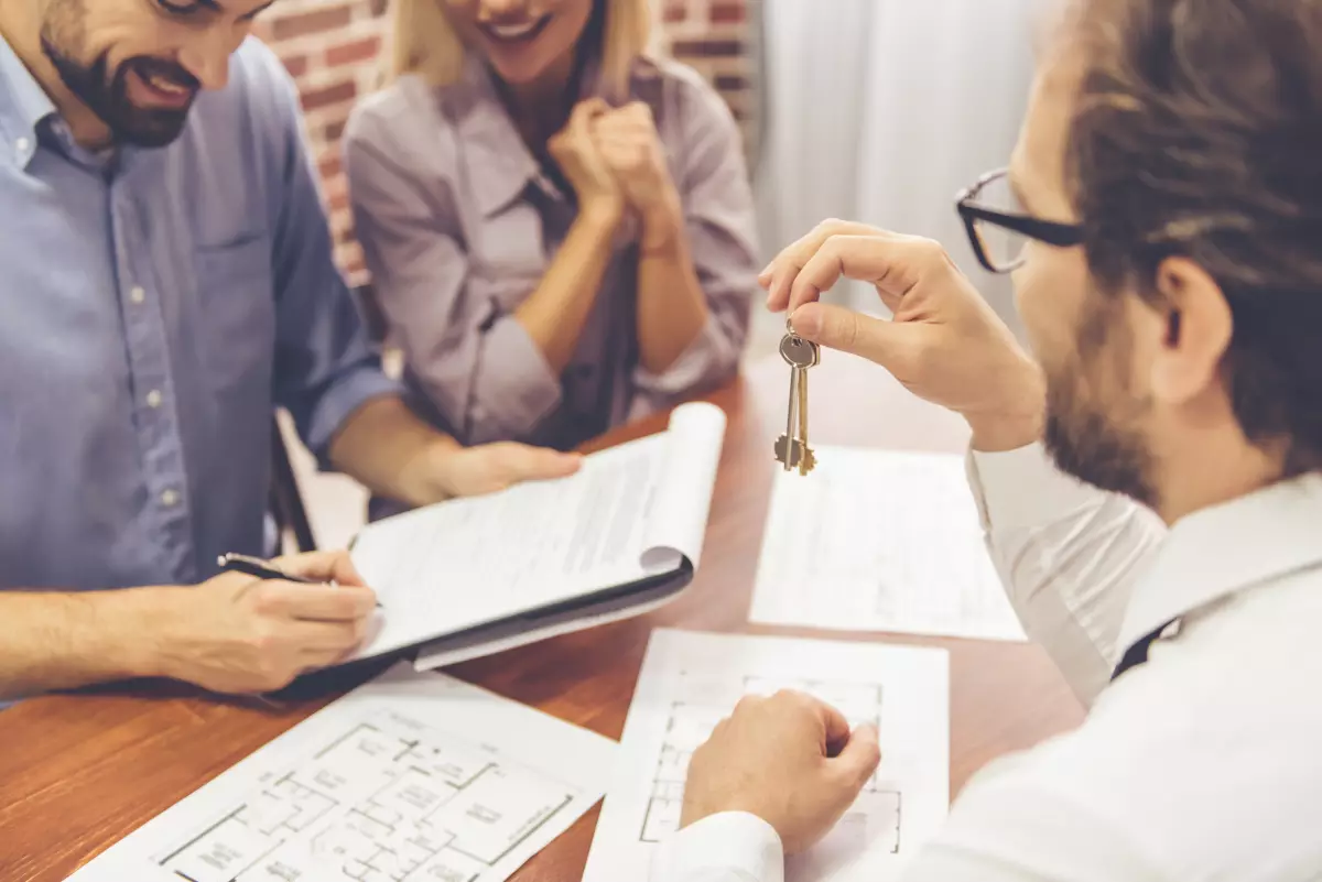Revente appartement neuf avant 5 ans – Un jeune couple signe un acte d’achat pour un logement neuf