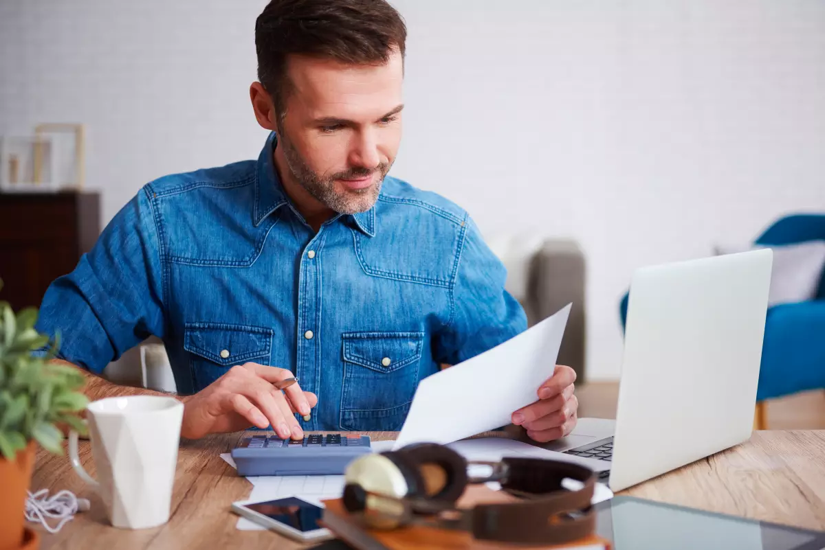 Quelles sont les charges que l'on peut déduire au régime réel ? Homme calculant ses dépenses