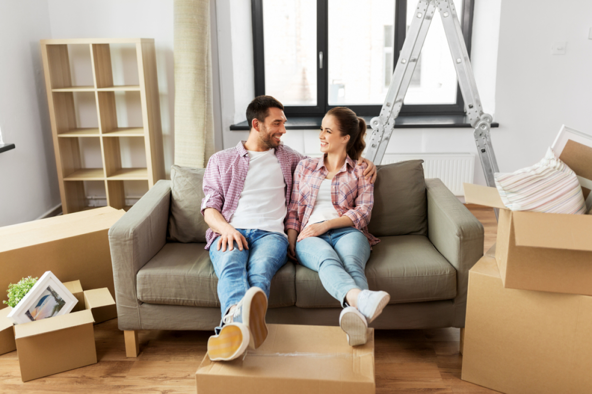 Meilleur tarif d’électricité - Un couple est sur un canapé au milieu des cartons de déménagement