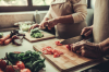 Maison partagée senior – Deux personnes âgées en train de cuisiner des légumes