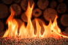 Chauffage écologique - Des granulés de bois en feu devant une pile de bûches