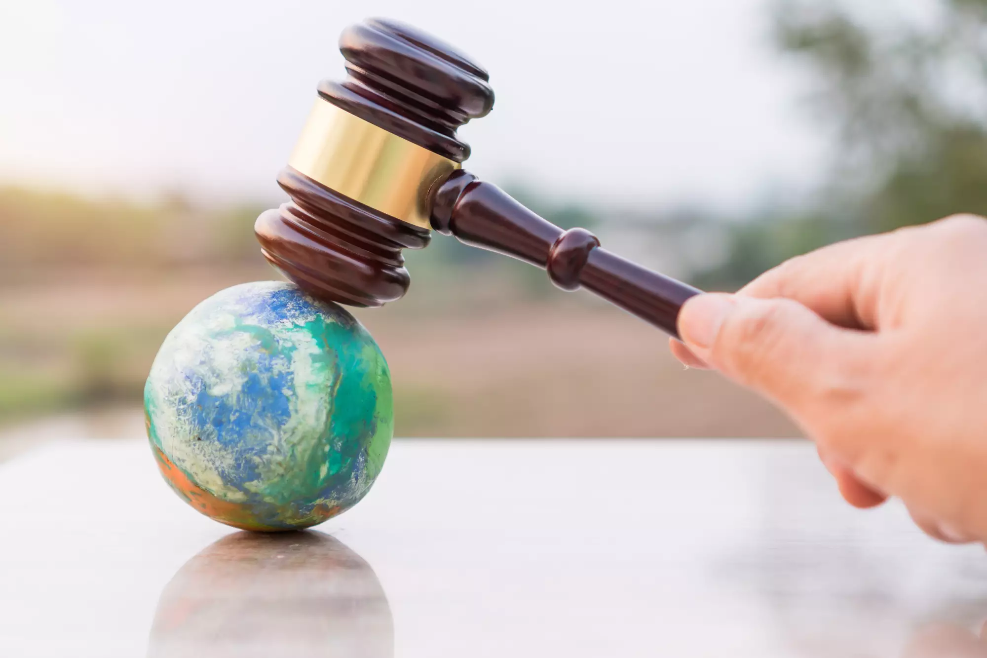 un marteau de juge sur une maquette de la planète terre