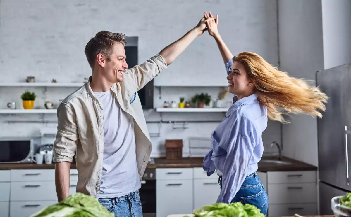  couple heureux dansant dans son nouvel appartement