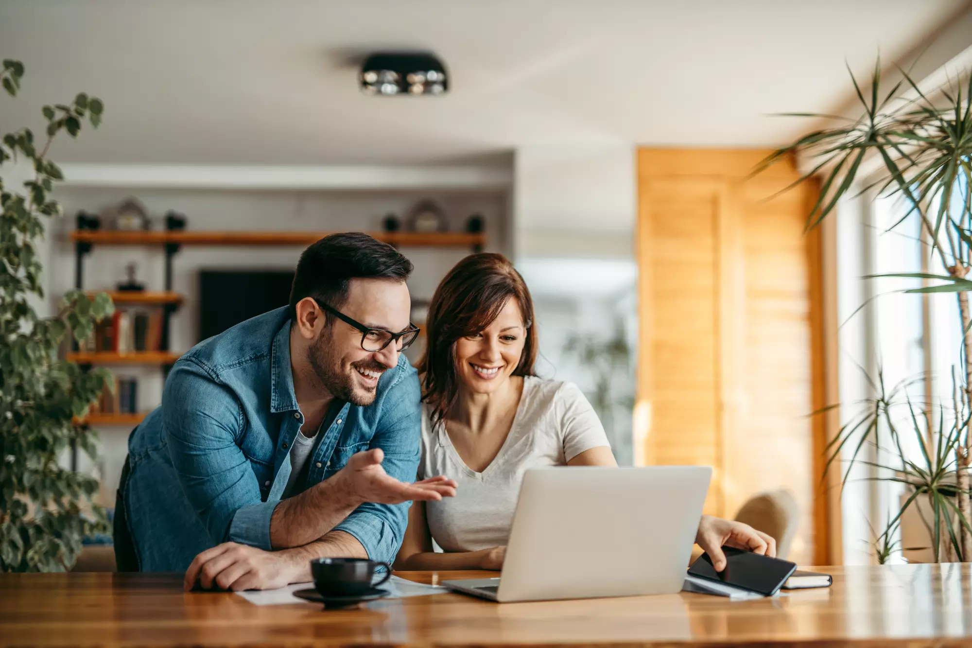 Un couple consulte les offres immobilières sur un ordinateur portable