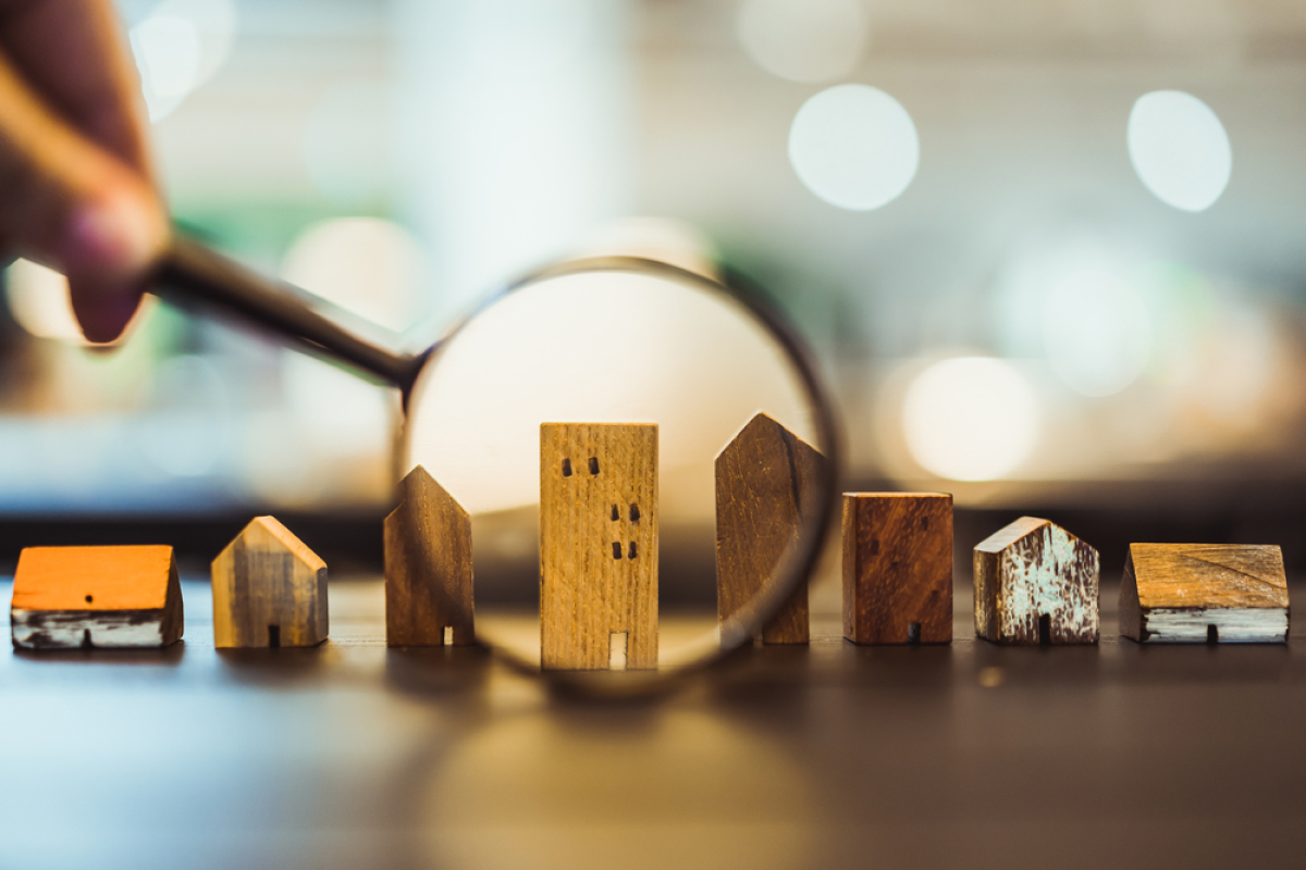 investissement locatif neuf ou ancien – Une loupe qui grossit un immeuble miniature en bois