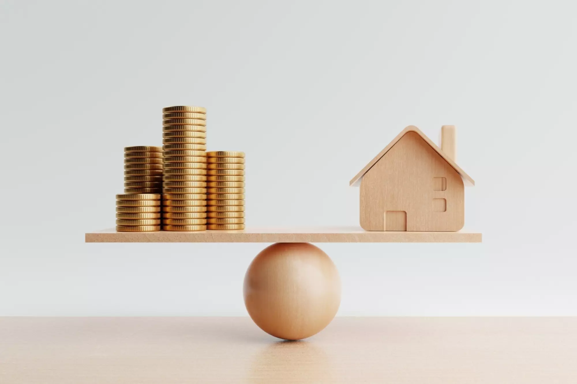 Balance en bois avec un tas de pièce et une maison