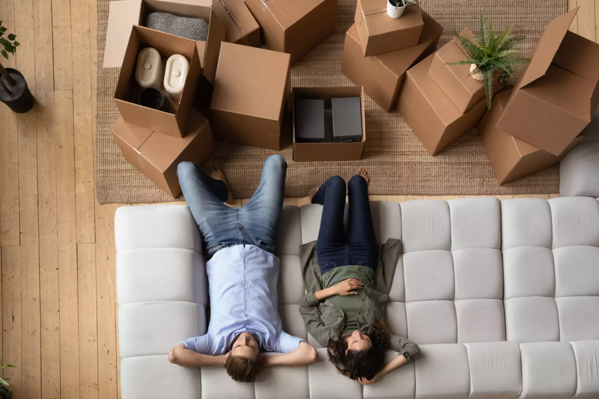 Un couple assis sur son canapé dans son nouveau logement fraîchement aménagé