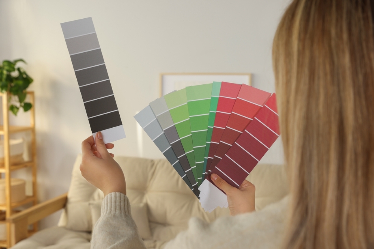  Maison neuve clé en main – Une femme en train de comparer les couleurs de peinture pour les murs de sa maison 