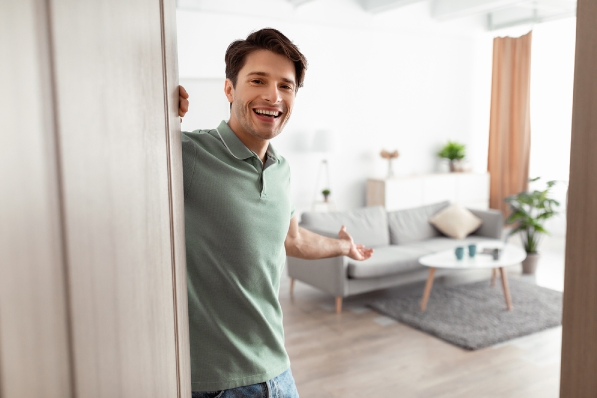 hausse des taux immobiliers – un jeune homme ouvre la porte de son appartement neuf