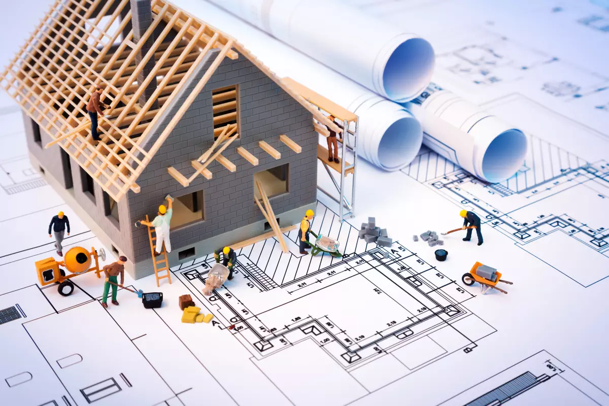 construction hors site – une maquette de maison en construction posée sur des plans