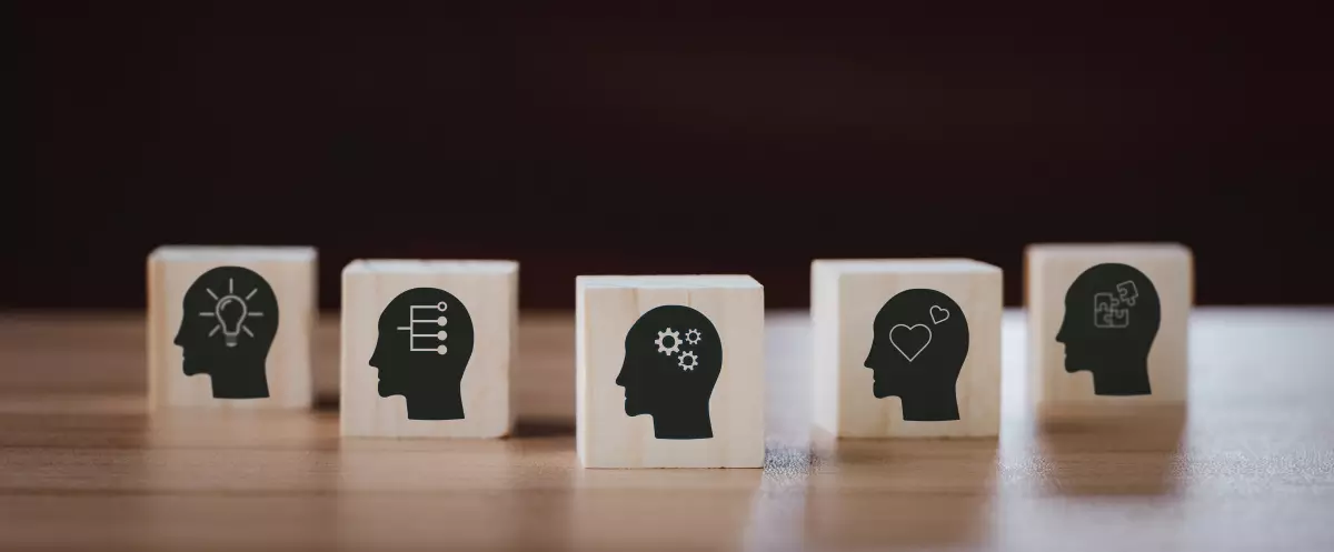 les qualités personnelles pour devenir promoteur sont nombreuses. des carrés de bois avec des visages silhouettes de profils sur lesquels sont dessinés des pictogrammes