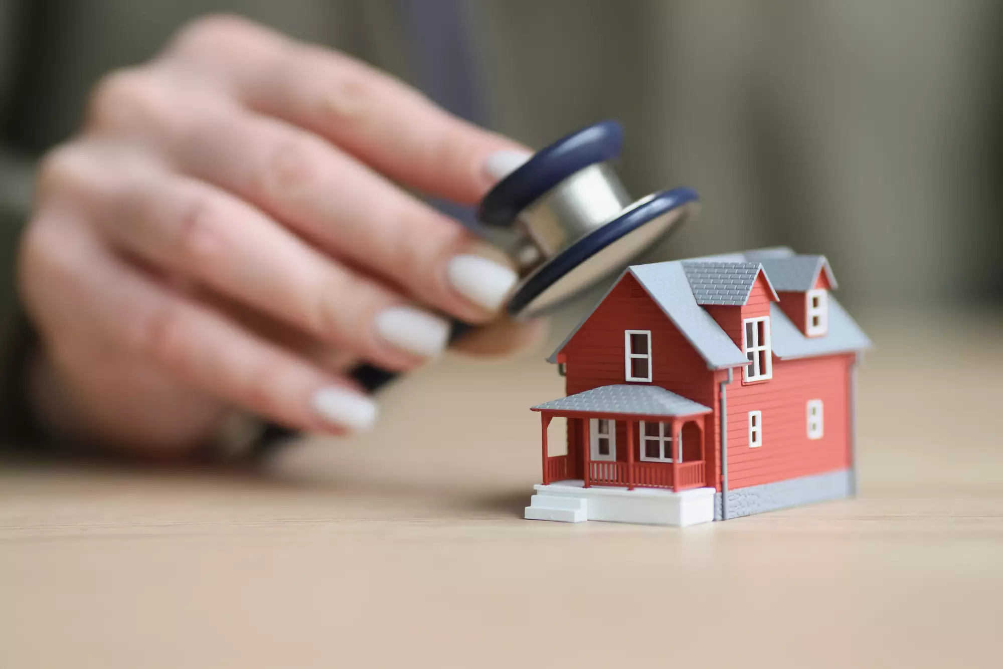 une femme ausculte une maison au stéthoscope