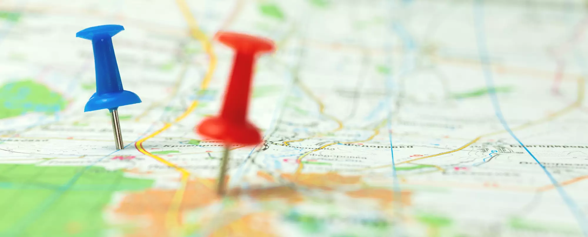 Punaises colorées plantées dans une carte